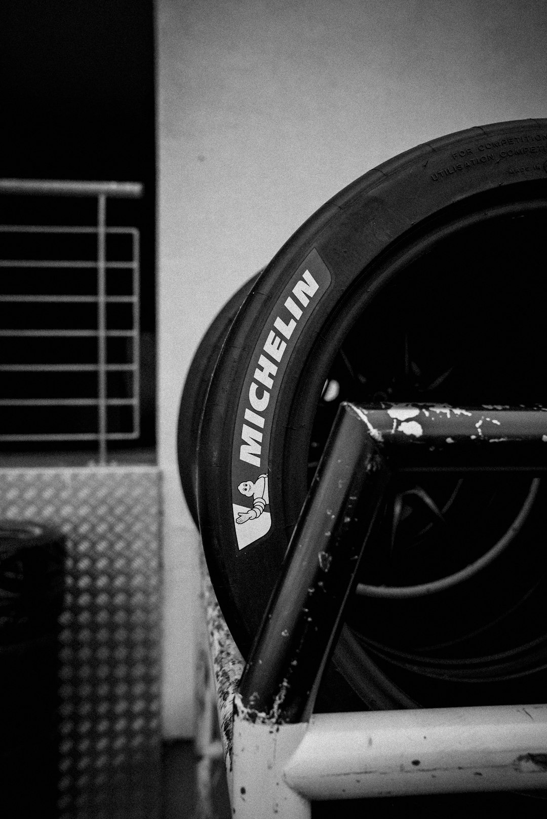 Michelin racing tire leaning on a metal rack.